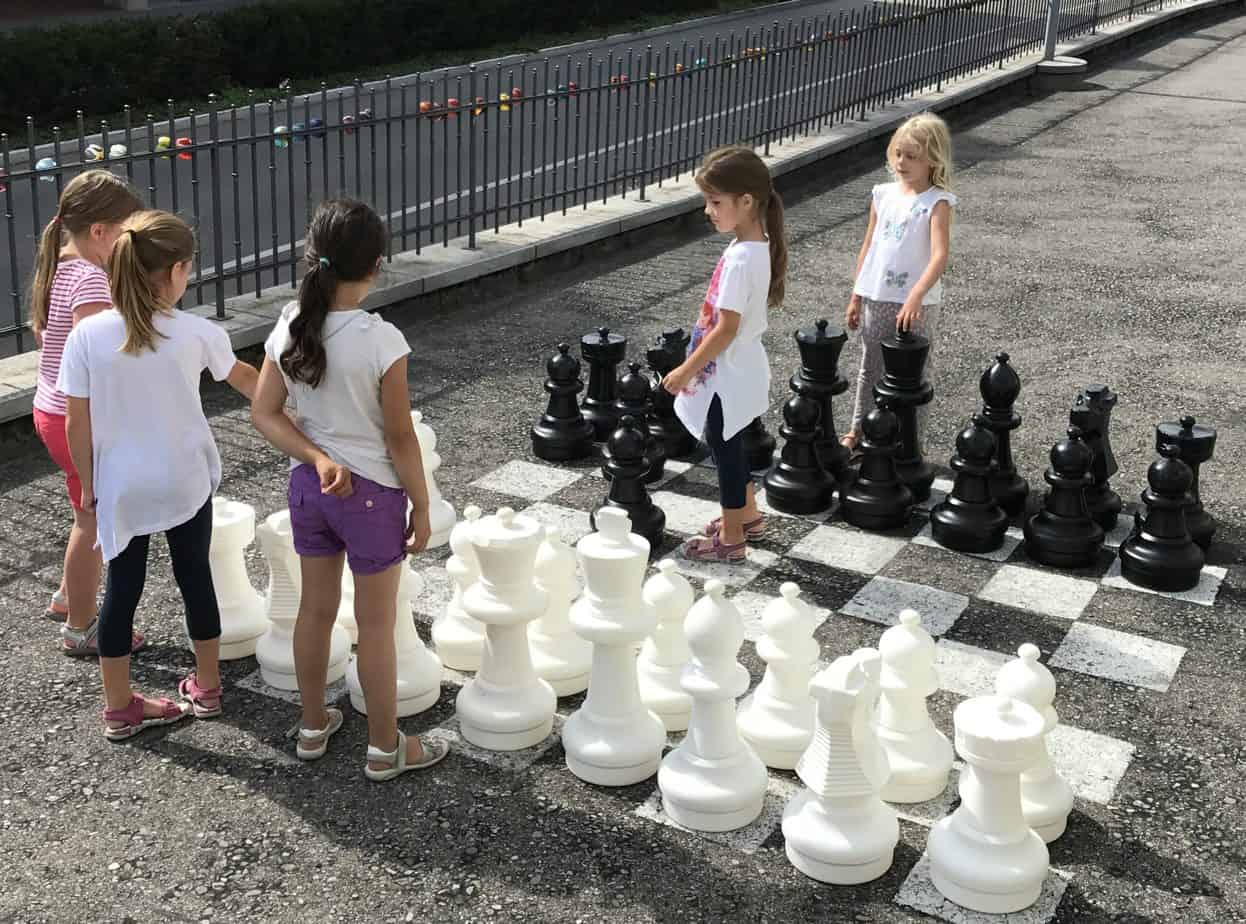Group of girls playing an outdoor chess game