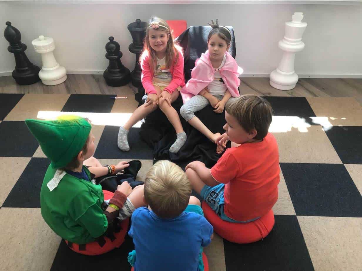 Children sitting on a big chessboard