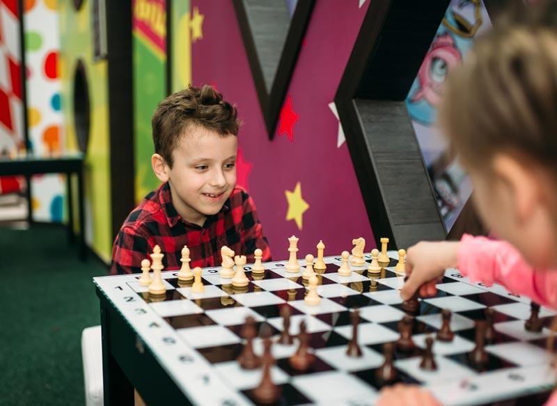 Children in the vacation camp play chess