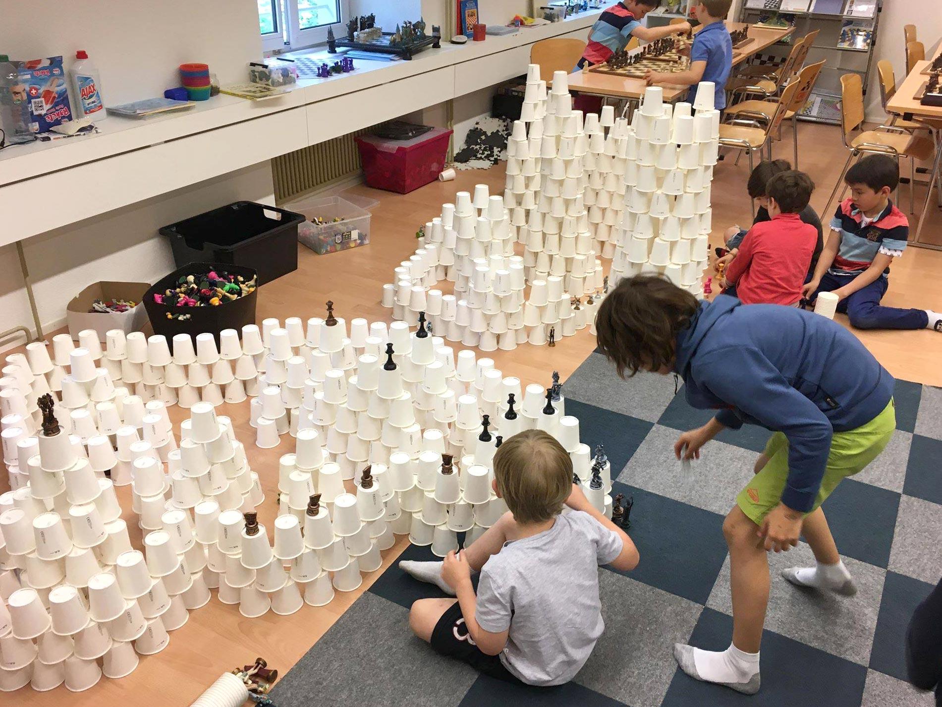 Kinder bauen eine Burg aus Pappbechern